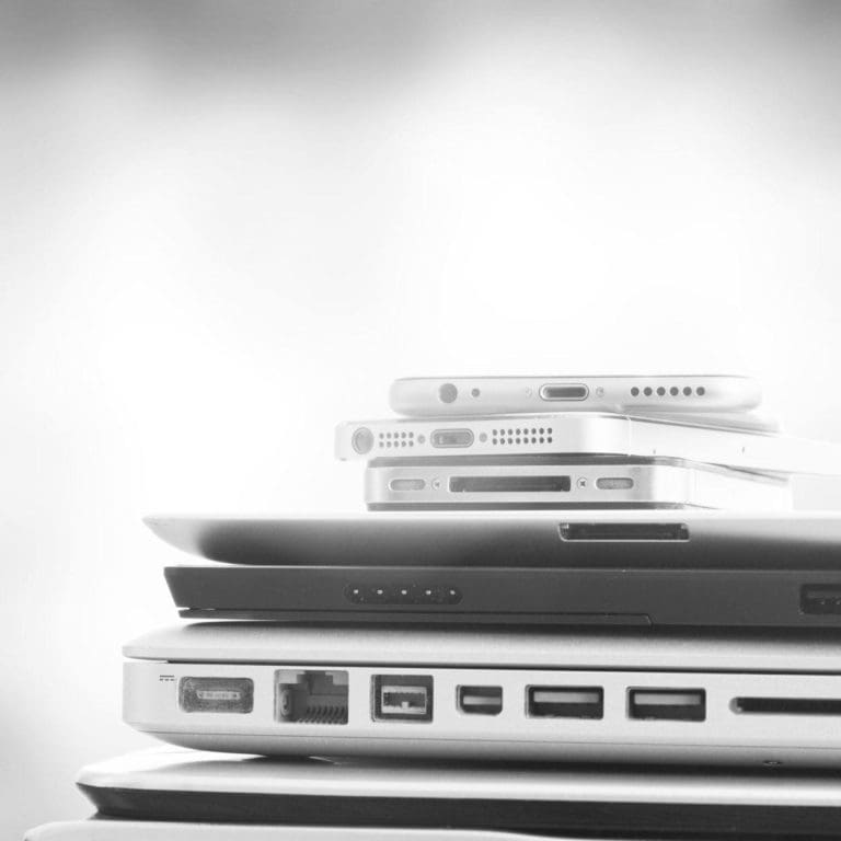 closeup of several laptops and smartphones stacked
